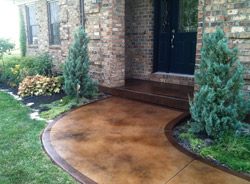 A stained concrete entryway in light brown with a dark brown border.