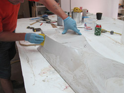 Forming concrete with fabric - Once all your coats are on, do a final sand to 120 grit. Then apply a layer of regular Bondo. This will allow you to fill in any low points or any possible wrinkling that may have occurred. When this coat hardens, you can sand to 120 again and work the surface into the final shape. Apply more Bondo if necessary to build up any area that is still too low or contains any imperfections.