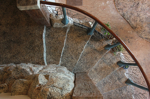  stamped GFRC staircase that resembles rock and leads into the basement-level man cave, graced by a sun-and-clouds water feature on the wall next to the staircase.