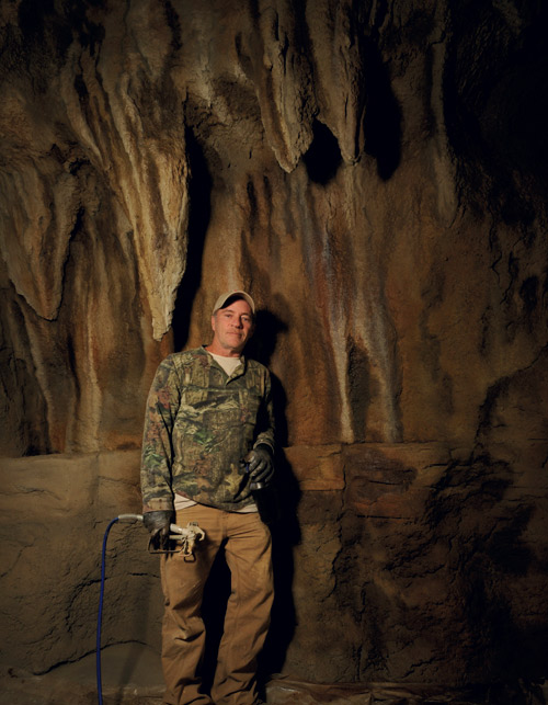 Thom Hunt stands next to one of his concrete stalagmite walls.