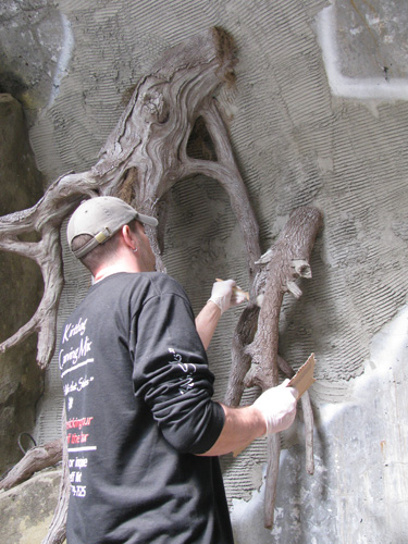 An attendee creates realistic tree roots out of concrete to give this place an underground feel.