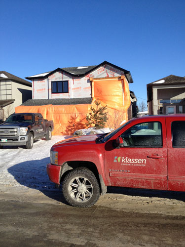 A red truck sits in front of a house that is being prepped for cold weather carving.
