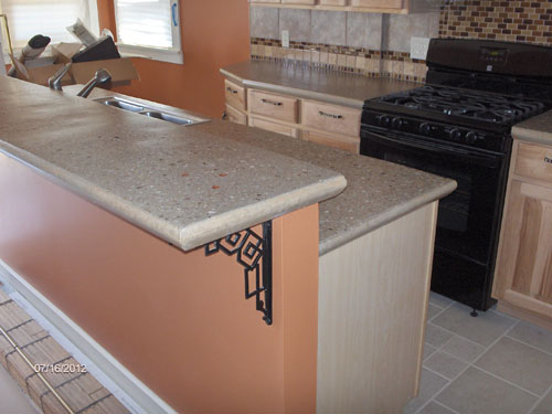 A double tier countertop in a kitchen in light gray with aggregate.