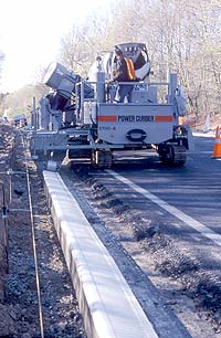 Curbs and Gutters machine in an industrial highway setting. Curbing machines make light work of curbing streets.