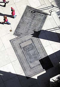 Sandblasted concrete in a decorative rug pattern on a city sidewalk possible from using a concrete stencil -Rafco Brickform Decorative Sandblast Stencils