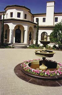 A stamped concrete driveway shows off this spectacular home and concrete fountain.
