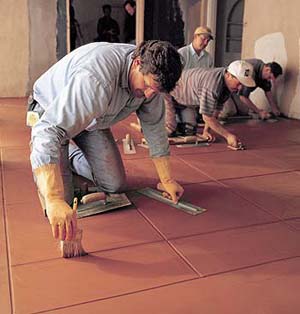 Four men working on an integrally colored floor cleaning up the decorative joints. Once used almost exclusively as an exterior building material, Davis Colors are now equally at home in residences and commercial interiors.