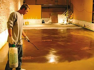 Mark Donaldson apply concrete sealer to an acid stained concrete floor in a basement.