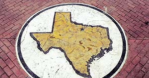 A stencil was used on a concrete surface in the shape of Texas by Stencil Systems