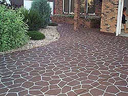 Stenciled concrete brick red driveway with white colored grout by Stencil Systems