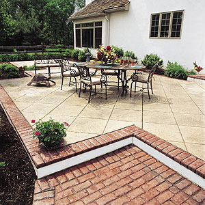 An elegant concrete patio that has a stamped faux brick edge and a main area that is stamped on the bias.