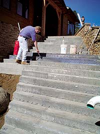 A liquid polymer bond coat is applied to the prepared substrate prior to installation of the polymer-modified topping. Wire lathing has been installed on the stair risers to increase adhesion.