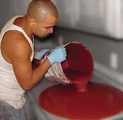 Pouring a bucket of red color for a concrete countertop