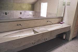 Simple gray concrete countertops by Fu-Tung Cheng give this bathroom an industrial and sleek look.