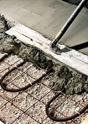 Close up view of placing concrete over radiant heat coils.