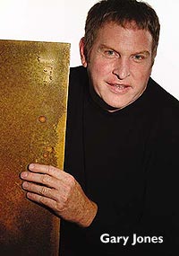 Colormaker Floors - Gary Jones holds a sample board of their concrete coatings product.