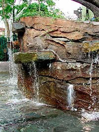 Faux Rock Pond shows discoloration from the constant contact with water has white efflorescence appearing.