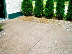 Exposed aggregate patio stained by iron rich sprinkler water has been cleaned using a specialized solution and looks new.