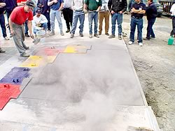 A concrete slab has been covered in a color release agent prior to a concrete stamp being placed upon the perfectly cured concrete slab.