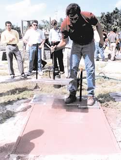 Stamping integrally colored concrete has both positive and negative reviews. Here a test concrete slab has stamping mats applied and are being tamped with a concrete tamper.