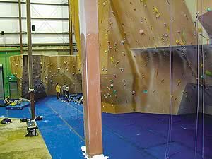 Vertical cementitious overlay on an indoor climbing wall.