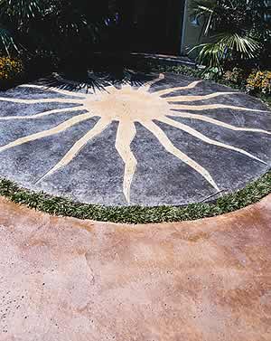 Acid stained concrete application is used to create this outdoor space where the artist stained a sun on the patio to add an artistic touch to the outdoors.