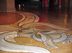 An indoor floor that has been engraved and stained with SuperKrete products in the shape of what looks like an abstract owl.