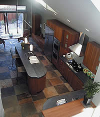 An overhead view of a large kitchen with a concrete countertop on the cooking island.