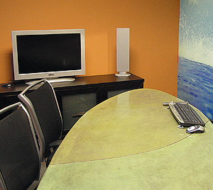 The finished tabletop - Twelve-foot long concrete surfboard table used with clients in Board Room. Cast-in-place custom design. Chemical stain, two-part epoxy finish.