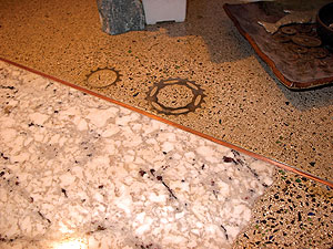 concrete countertop with ground copper and metal gears using glass as an aggregate in concrete.