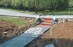 Integrally colored concrete: Finishers - KML Finishers prepare steps for release agent & stamping.