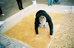Clark Branum of Brickform Products - Clark Branum of Brickform Products removes blemishes, including pencil marks, from a stained slab during demonstrations at the ASCC annual meeting. The color was later restored by applying a matched water-based acrylic stain with an airless sprayer.