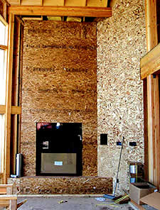 Concrete Fireplace in the construction phase with chip board backer board and the fireplace insert already installed.