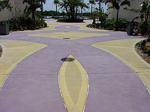 A purple and yellow concrete courtyard featuring a circular mag brush finish on the concrete.