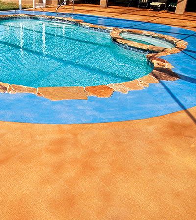 GLC3 Concrete Pool Deck - He applied an overlay over the area around the pool and created an ocean blue both in the pool and around it, using SuperStone integral blue color in the overlay and blue SuperStone dyes on the surface. On the rest of the pool deck, he used SuperStone acid stains, tinting and dyes to create a sandy color on the surface. Then he finished with a clear, solvent-based, non-skid acrylic sealer, resulting in a beach away from the beach.
