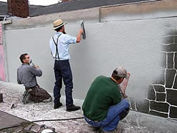 Applying and troweling a stenciled overlay. - Concrete stencil supplier Artcrete Inc. offers both the spray-on and tilt-up approaches to vertical concrete applications. The use of stenciling on vertical surfaces is just now becoming more popular, says Artcrete national director of training Steve Peters.
