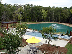 concrete patio and pool deck in North Carolina sits near an all concrete home.