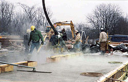 Concrete construction crew working with freshly poured warm water concrete in a cold environment.