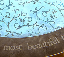 Acanthus Concrete Stain Designs created this light teal and brown ivy patterned concrete floor emblem. 