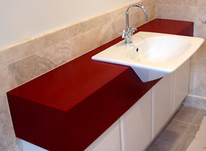 This red bathroom vanity combined a complicated shape with an unusual sink. The designer helped the installation team understand exactly how the sink should be mounted.