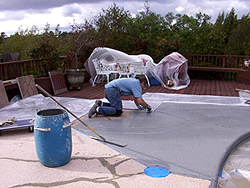 applying a coat on a concrete pooldeck preparing for stenciling application