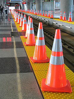 Safetly cones line the edge of a railway track.