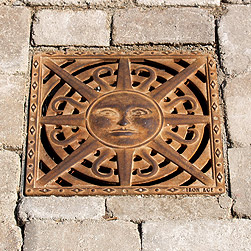 Decorative grate cover in the shape of a sun.