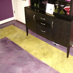 A green border on a purple concrete floor using stains.