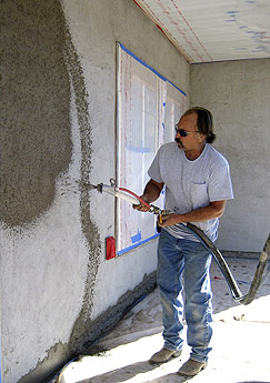 The team at Tajmawall applies shotcrete and pressure molds to the exterior of a house.
