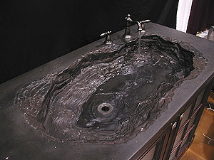 A concrete sink that is made in black colors.