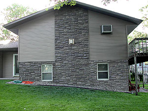 An exterior house wall using Synthetic Rock GFRC techniques. all rocks have speckles. Speckles can be created by applying color with aerosol cans that spit, using piston pumps or airless sprayers and blowing the color with a fan, or even flinging color from a paint stick with the flick of the wrist.