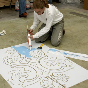 Shellie Rigsby applies a stencil to this concrete floor.