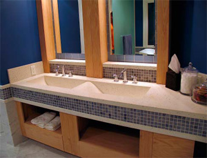 Concrete countertop with double sinks inlayed in a bathroom.
