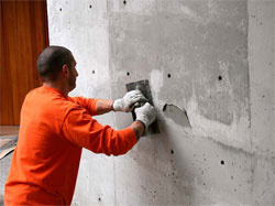 Steve Fox of Seattle's SAK and Patch applies a coat of Raecos SkimWall in Seattle Gray. The project is a modern residential project whose architect wanted to retain the look of the cast-in-place concrete walls while masking the color variations between pour lines.